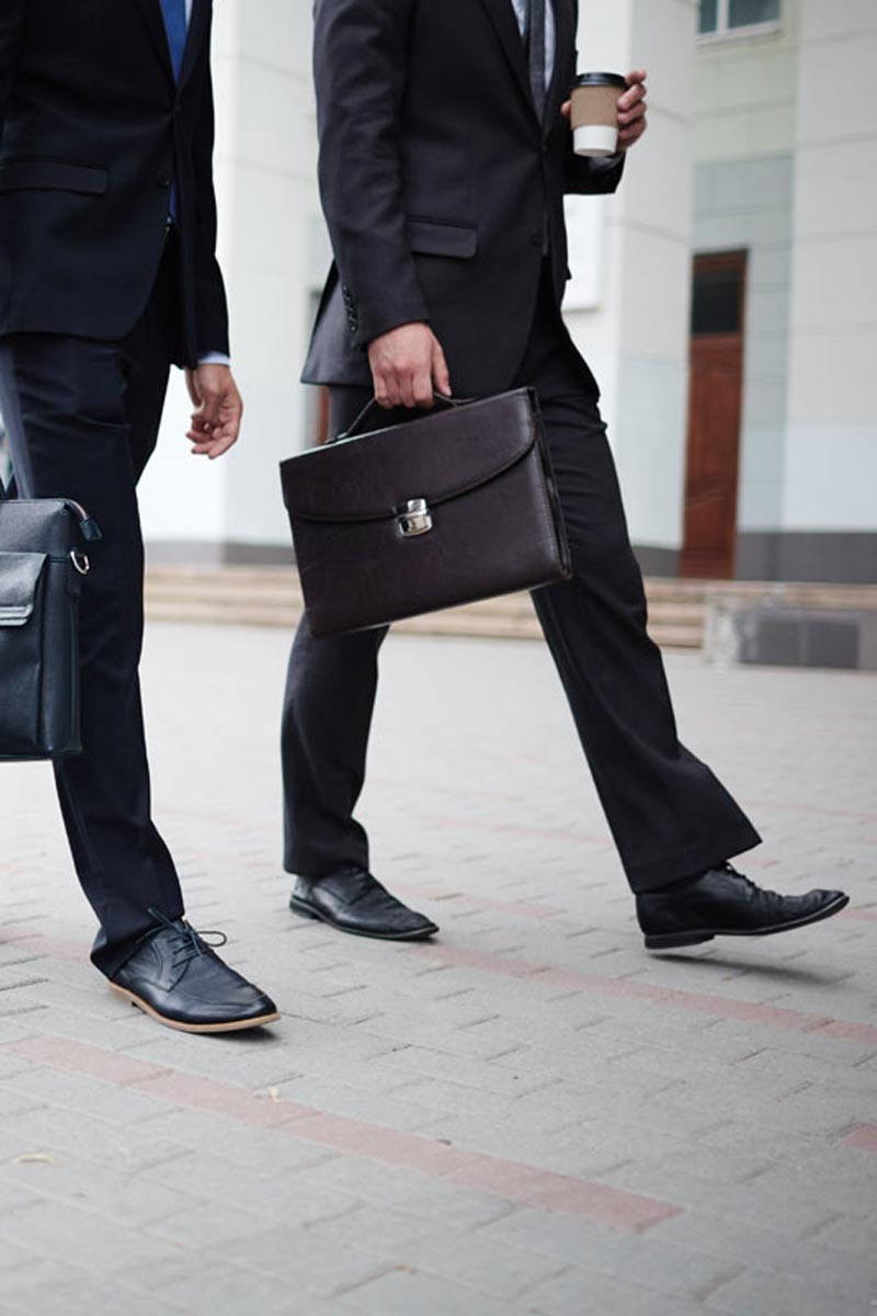 well dressed business people walking down interlock brick street